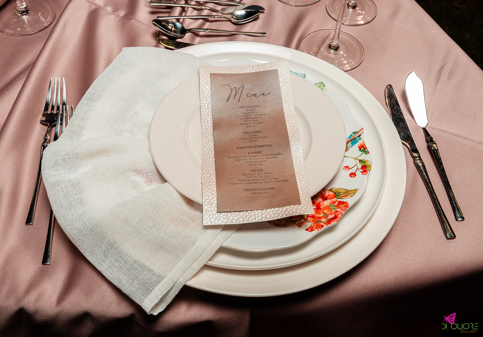 Plate with a linen napkin and a kraft-paper menu on a dusty-pink cloth