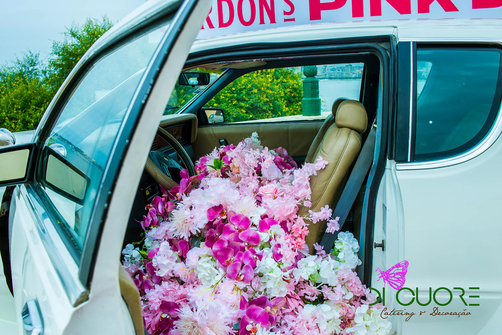Banco de couro de um carro antigo coberto de orquídeas fúcsia e flores brancas e cor-de-rosa