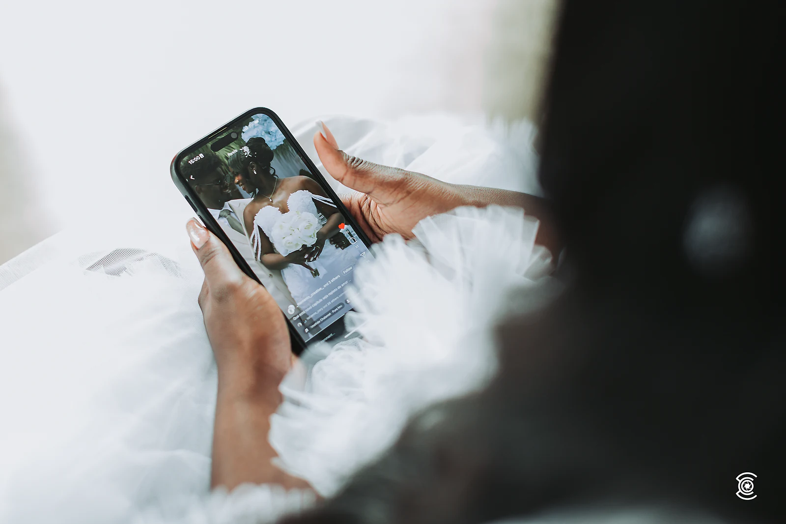 A noiva vê fotografias no telemóvel durante a preparação