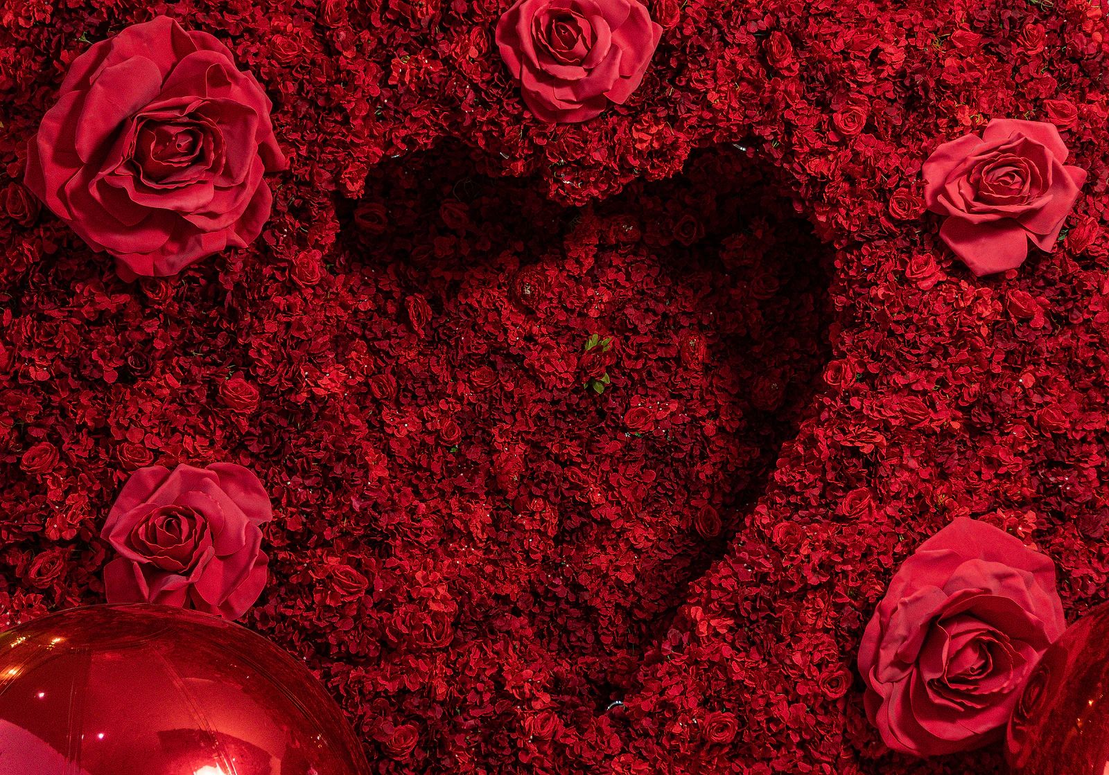 Pormenor do painel de rosas vermelhas, com o coração recortado ao centro e grandes rosas à volta, junto a uma esfera espelhada